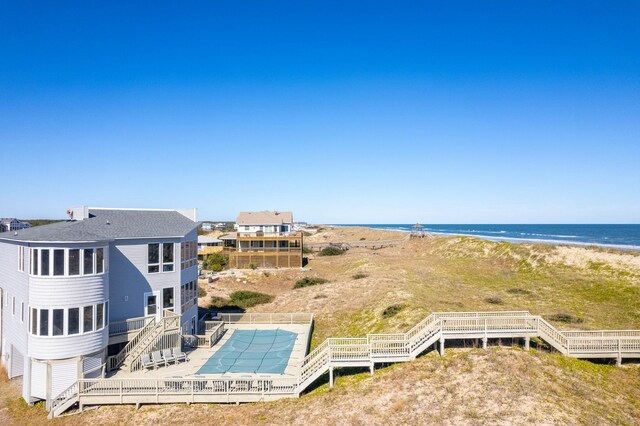 birds eye view of property with a water view and a view of the beach