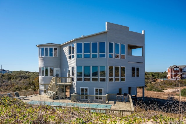 back of property featuring a patio area, stairs, fence, and a fenced in pool