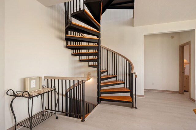 stairway featuring wood finished floors and baseboards