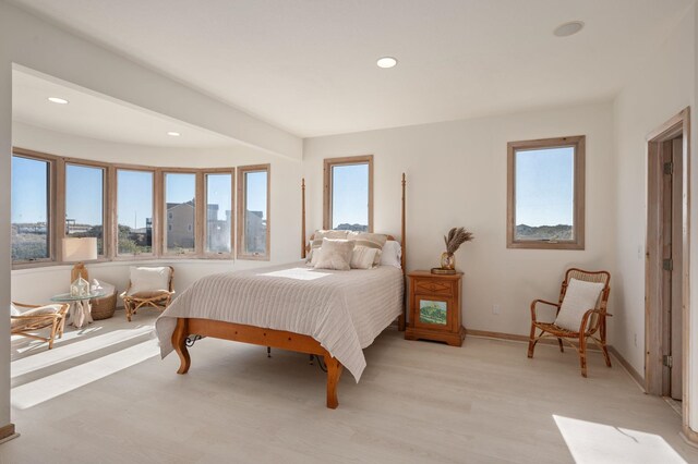 bedroom with baseboards, light wood-type flooring, and recessed lighting