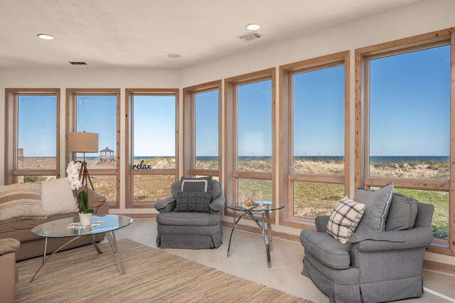 sunroom / solarium with a water view, visible vents, and a wealth of natural light