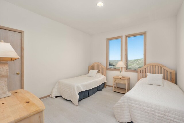 bedroom featuring baseboards and wood finished floors