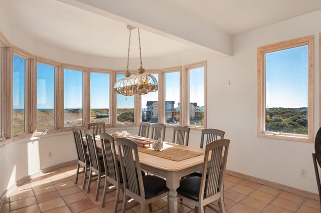 dining area featuring light tile patterned flooring, a notable chandelier, and baseboards