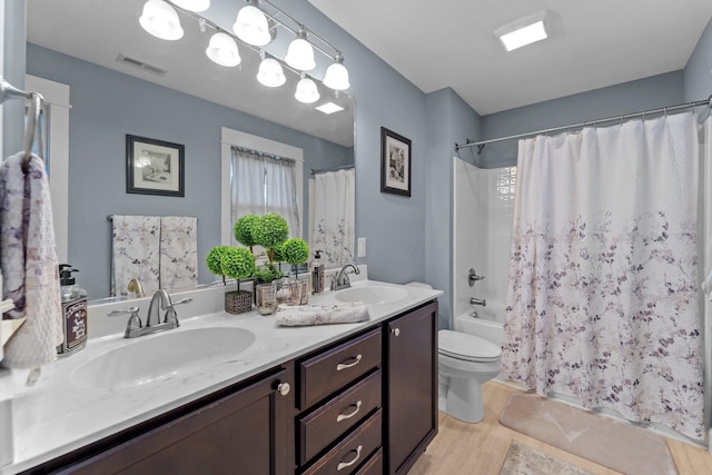 bathroom featuring shower / bath combo with shower curtain, visible vents, a sink, and double vanity