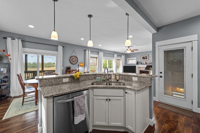 kitchen with stone countertops, white cabinets, dishwasher, decorative light fixtures, and a sink