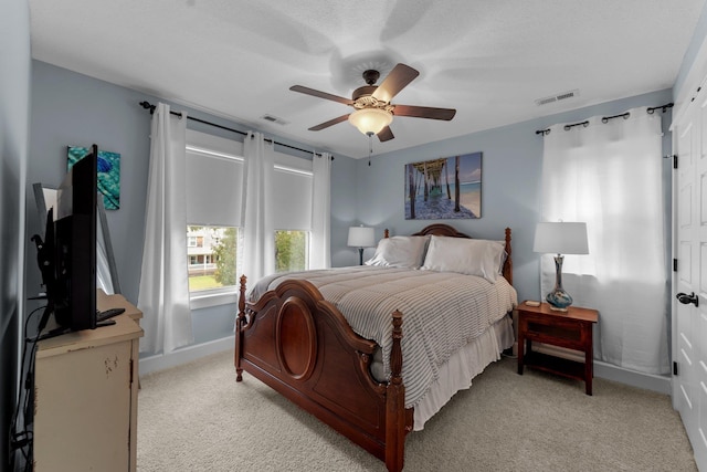 bedroom with light carpet, ceiling fan, and visible vents