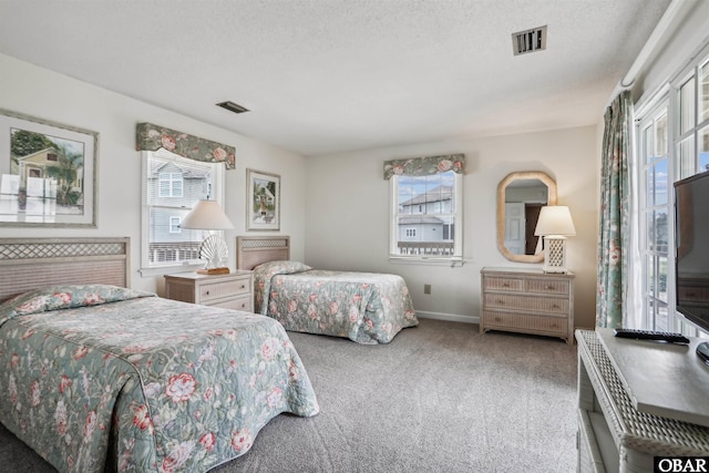 bedroom featuring carpet, visible vents, and a textured ceiling