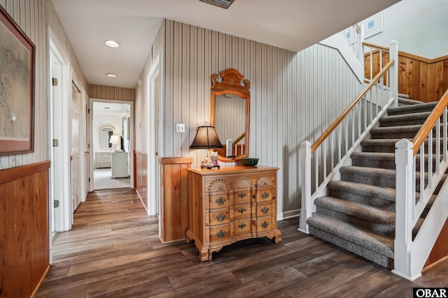 hallway with stairway, wood finished floors, and recessed lighting