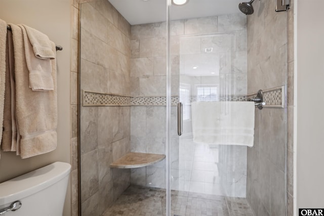 full bathroom featuring a shower stall and toilet