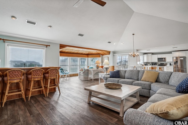 living area featuring lofted ceiling, dark wood-style flooring, visible vents, and ceiling fan with notable chandelier