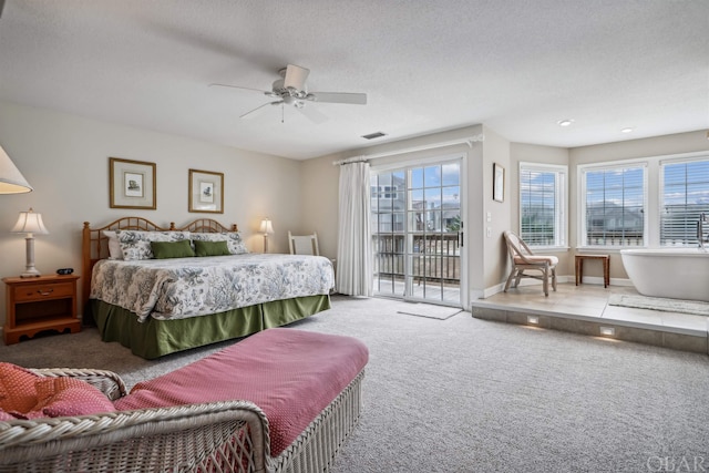 carpeted bedroom with access to exterior, visible vents, a textured ceiling, and baseboards