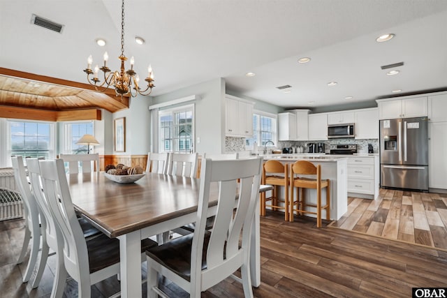 dining room featuring dark wood-style floors, recessed lighting, visible vents, and a notable chandelier