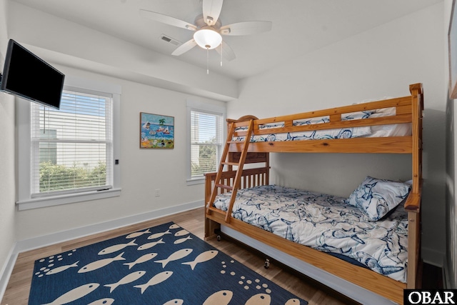 1207 Tail Wind Ct Lot 267, Corolla, NC 27927 - bedroom with multiple windows, baseboards, wood finished floors, and ceiling fan