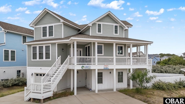 1207 Tail Wind Ct Lot 267, Corolla, NC 27927 - coastal inspired home featuring a shingled roof, covered porch, concrete driveway, and stairs