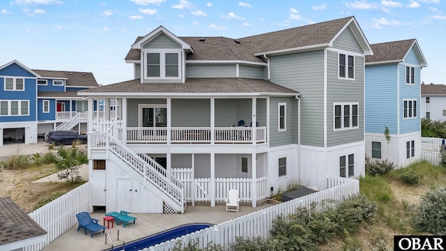 1207 Tail Wind Ct Lot 267, Corolla, NC 27927 - back of property featuring a shingled roof, a fenced backyard, a patio area, and stairs