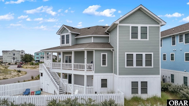 1207 Tail Wind Ct Lot 267, Corolla, NC 27927 - back of property with a shingled roof, a fenced backyard, board and batten siding, and a residential view