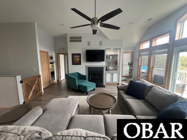 living room featuring visible vents, high vaulted ceiling, wood finished floors, and a fireplace