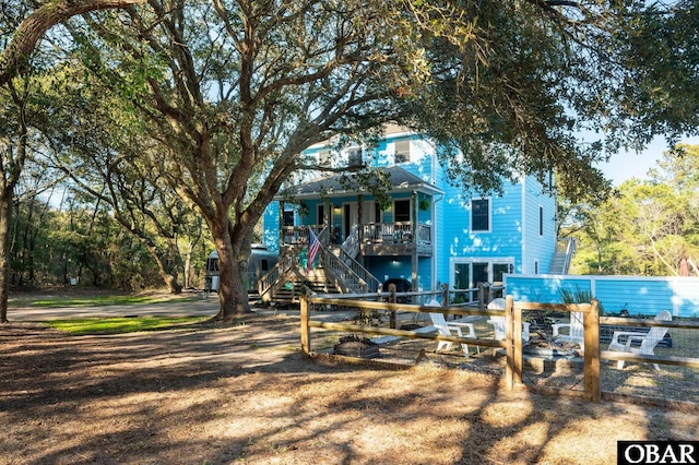 exterior space featuring stairs, fence, and covered porch