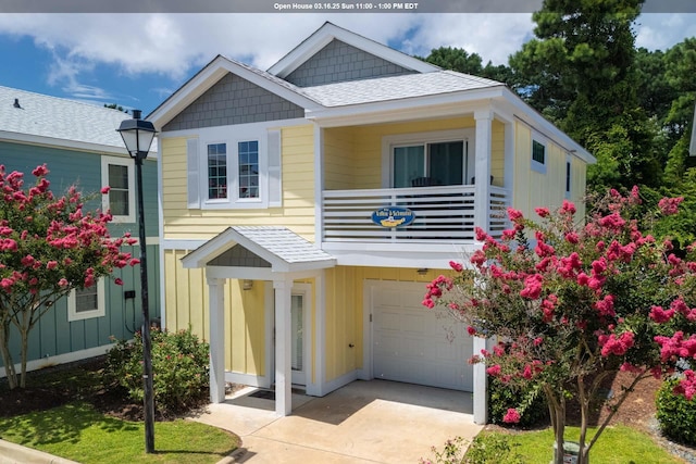 view of front of property with a balcony, board and batten siding, concrete driveway, and a garage