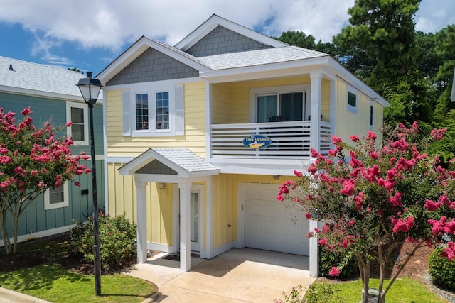 view of front of house with a balcony, board and batten siding, concrete driveway, and a garage