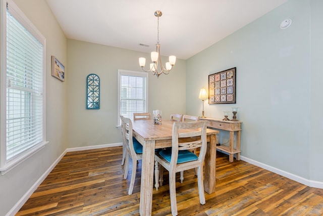 dining space featuring visible vents, a notable chandelier, baseboards, and dark wood-style flooring