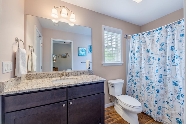 full bath with vanity, curtained shower, toilet, and wood finished floors