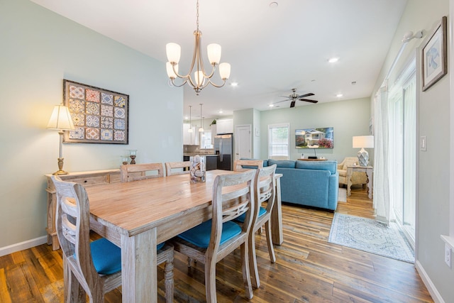 dining area featuring baseboards, hardwood / wood-style floors, and ceiling fan with notable chandelier