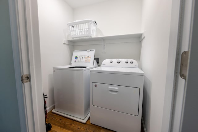 laundry area featuring laundry area, washing machine and dryer, and dark wood-type flooring