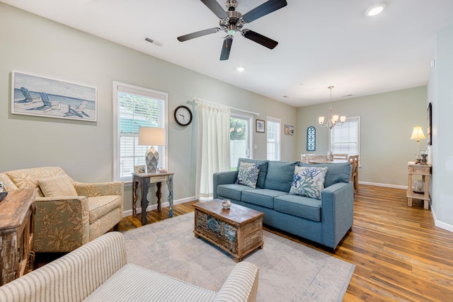 living room featuring visible vents, baseboards, and wood finished floors