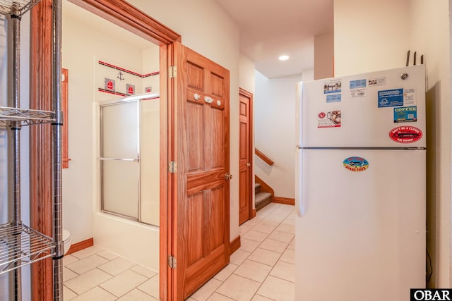 corridor with light tile patterned floors, recessed lighting, and stairs