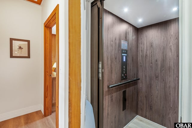 interior details with elevator, wood finished floors, recessed lighting, and baseboards