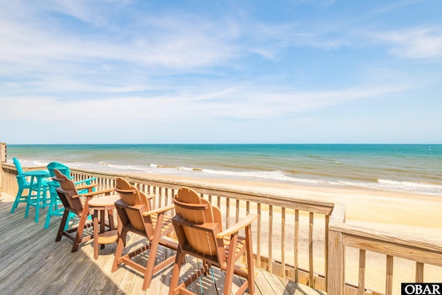wooden deck with a view of the beach and a water view