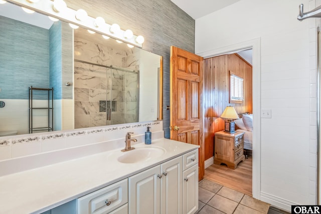 bathroom with a stall shower, tile patterned flooring, and vanity