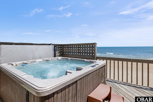 wooden deck with a view of the beach and a water view