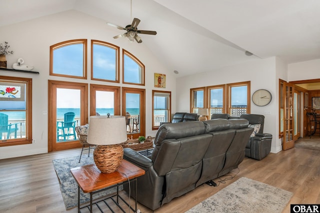living area featuring baseboards, a wealth of natural light, high vaulted ceiling, and ceiling fan