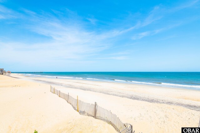 water view featuring a beach view and fence