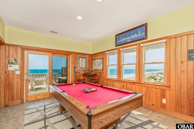 rec room featuring a water view, billiards, baseboards, visible vents, and wooden walls