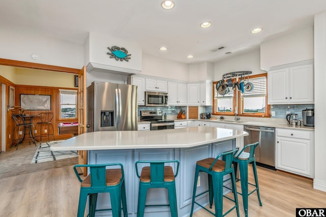 kitchen with a wealth of natural light, white cabinetry, and appliances with stainless steel finishes