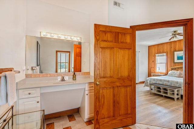 ensuite bathroom with visible vents, a ceiling fan, a high ceiling, vanity, and connected bathroom