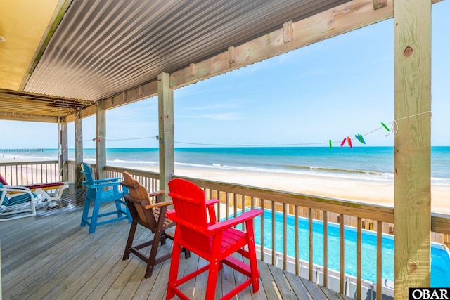 wooden terrace with a view of the beach and a water view
