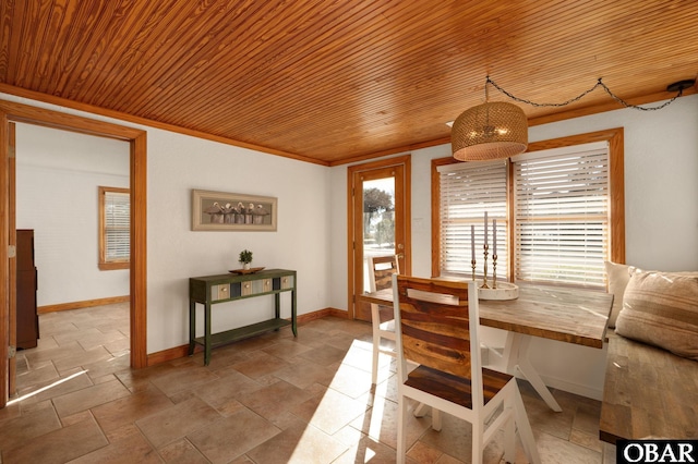 dining area with crown molding, stone tile flooring, plenty of natural light, and baseboards