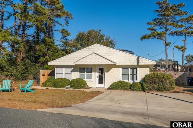 view of front of property with a front yard, fence, and stucco siding