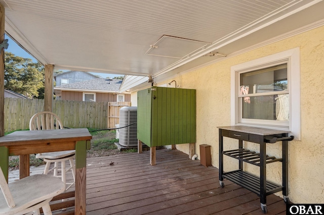 wooden terrace featuring central AC, outdoor dining area, and fence