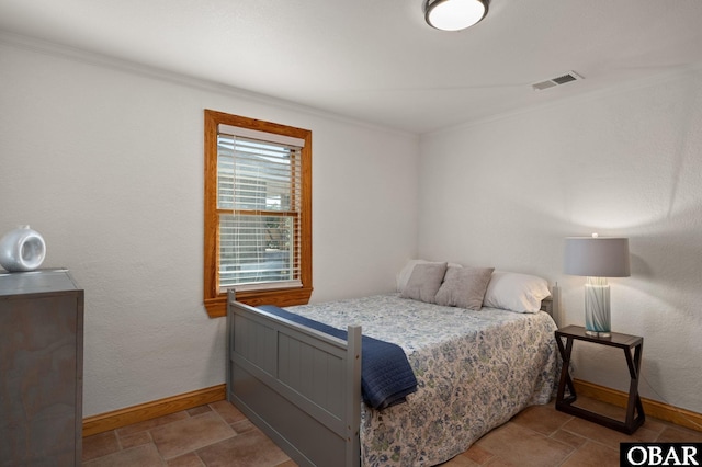 bedroom featuring stone finish floor, visible vents, crown molding, and baseboards