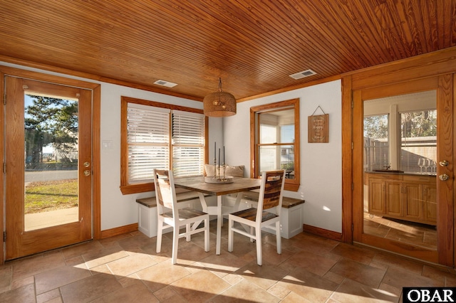 dining area featuring a wealth of natural light, wood ceiling, visible vents, and stone tile flooring