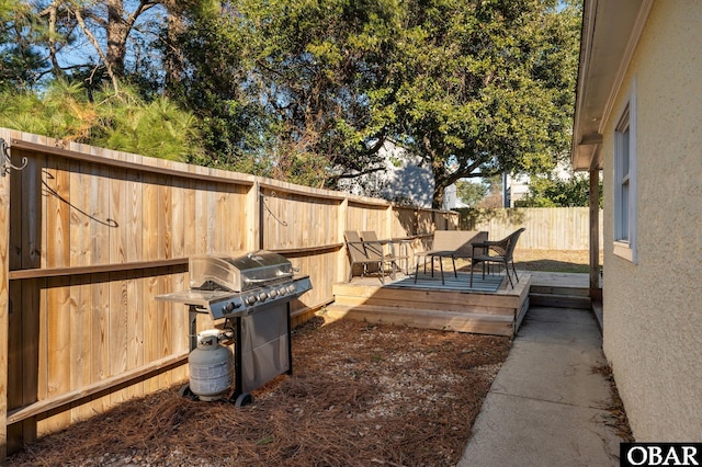 view of yard with a deck, outdoor dining space, and a fenced backyard