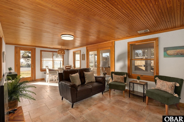 living area with wood ceiling, stone tile flooring, visible vents, and crown molding