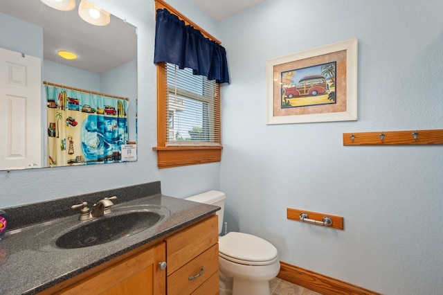 bathroom featuring curtained shower, baseboards, vanity, and toilet