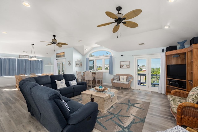 living area with lofted ceiling, ceiling fan, visible vents, baseboards, and light wood finished floors