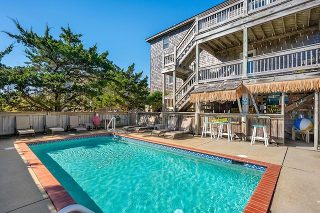 view of pool featuring a fenced in pool, a patio, outdoor dry bar, and fence